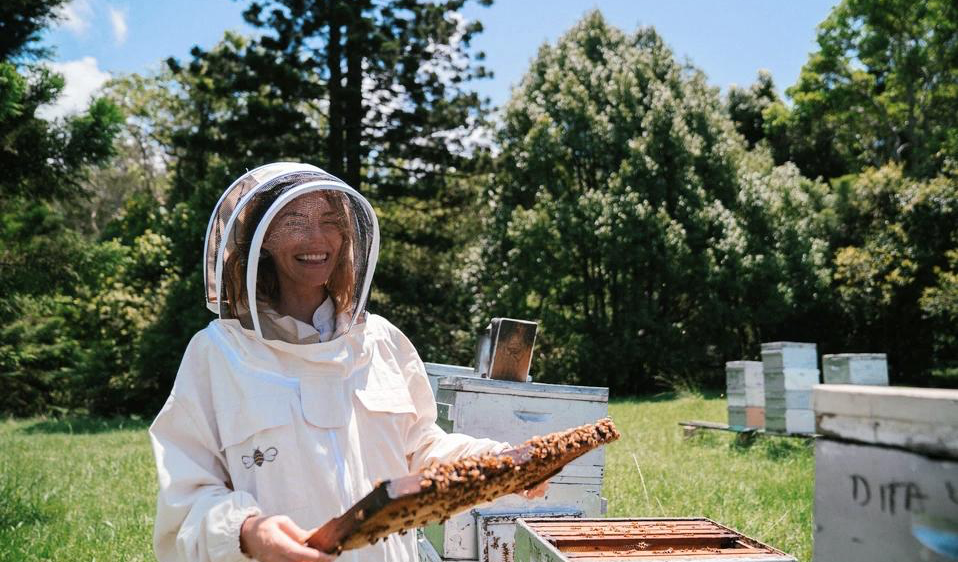 Smiling beekeeper holding a hive frame